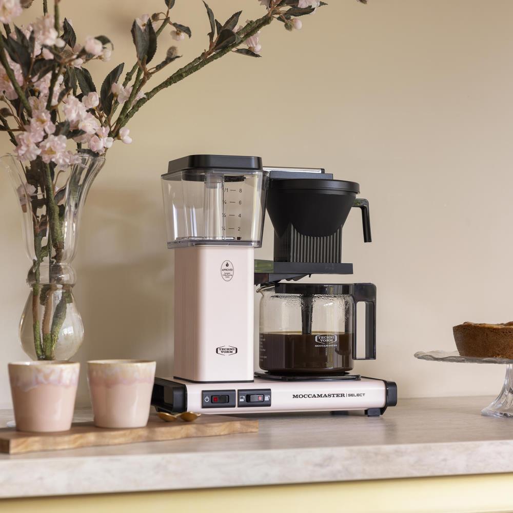 De KBG Select in Cherry Blossom met een volle glaskan verse koffie