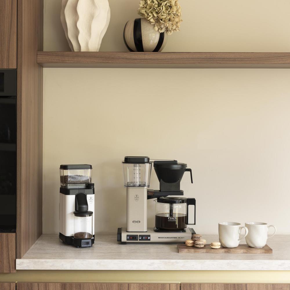 De KBG Select in Sandstone op een keukenblad, naast een koffiemolen