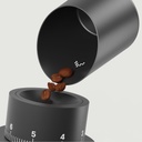 Subminimal Subscale die koffiebonen in de trechter van een koffiemolen giet